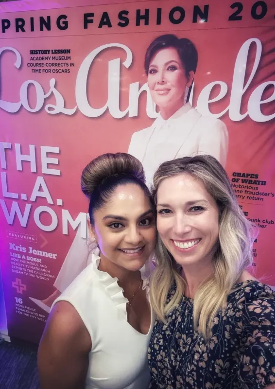 Two People Posing In Front Of A Magazine Cover Display