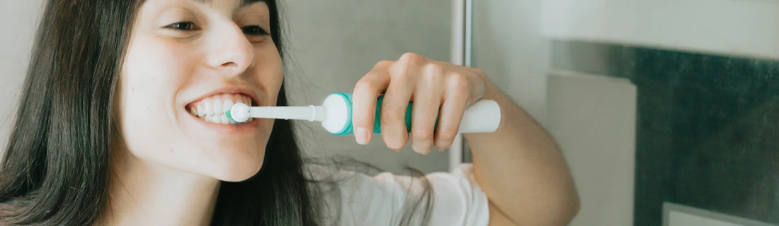 Person Brushing Teeth With An Electric Toothbrush