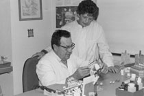 Dental Laboratory Professionals Examining A Dental Model While Working At A Desk