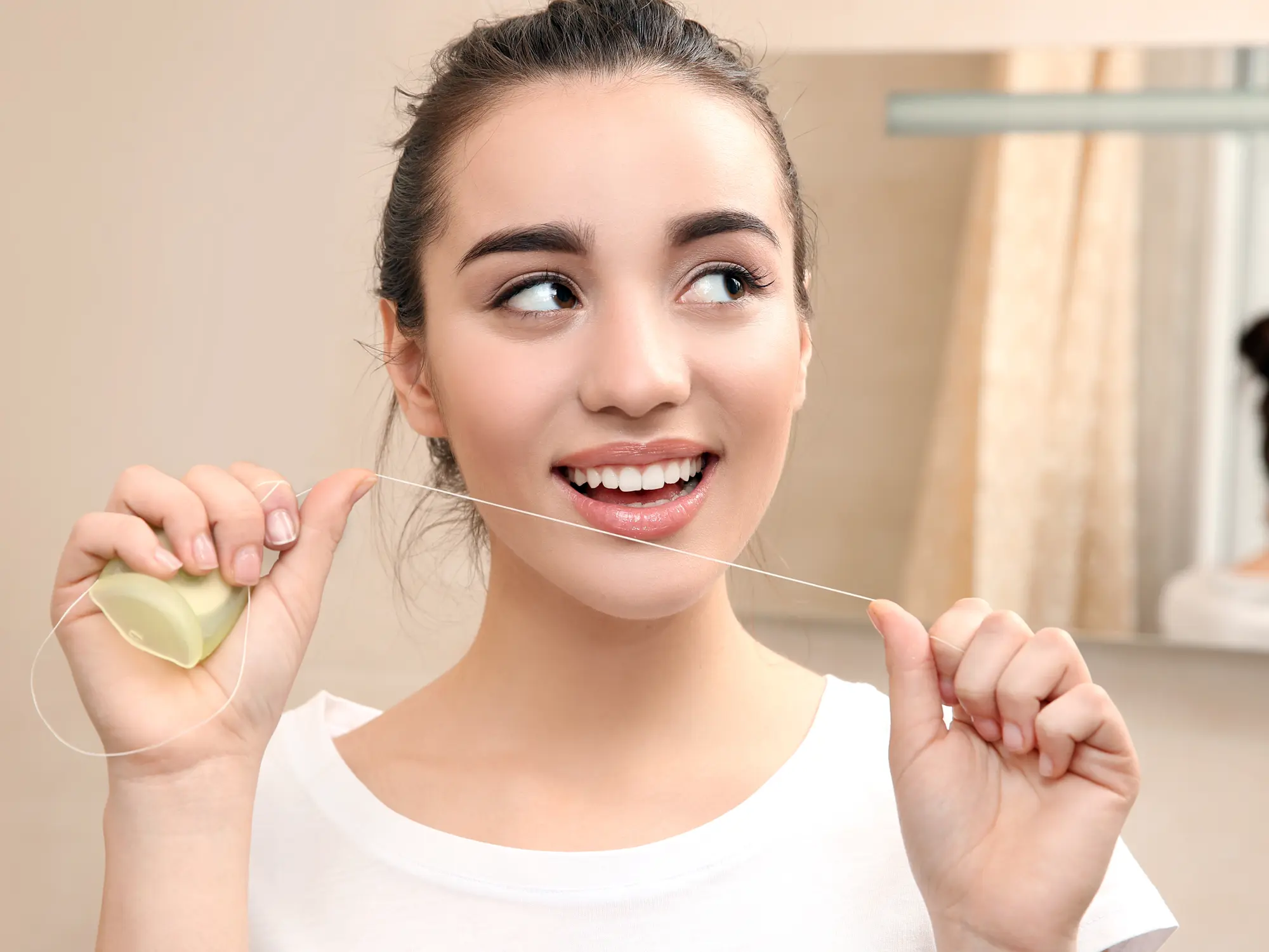 Person Using Dental Floss To Clean Teeth